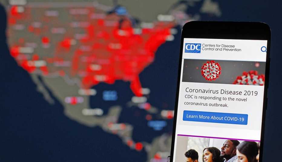  A Centers for Disease Control and Prevention (CDC) mobile web screen on the topic of the Coronavirus Disease 2019 is  displayed over an illustrated map of the United States that tracks the virus 