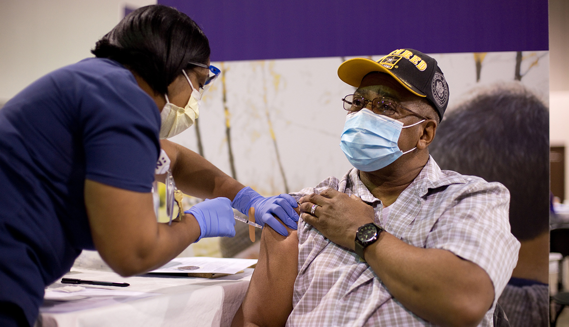 a health professional administers the covid vaccine to a retired army captain