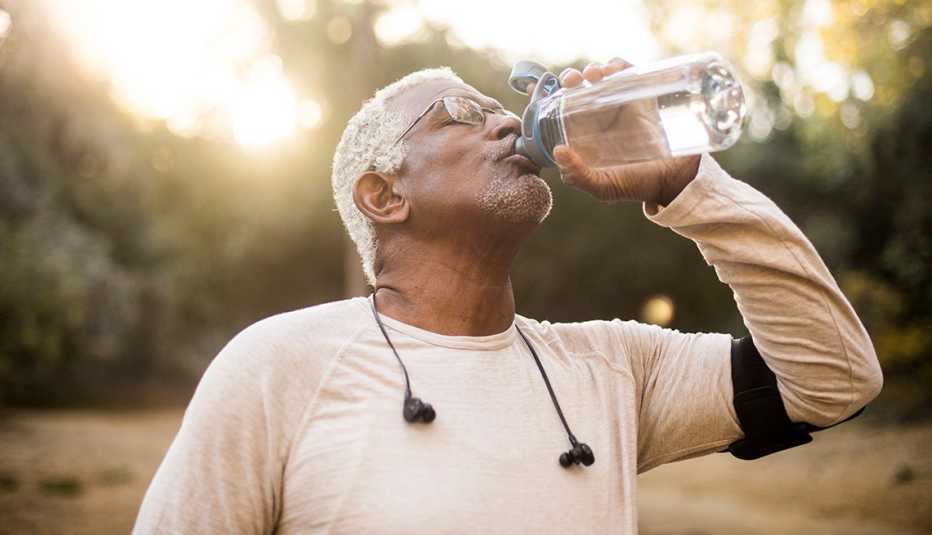 A man drinking water outdoors