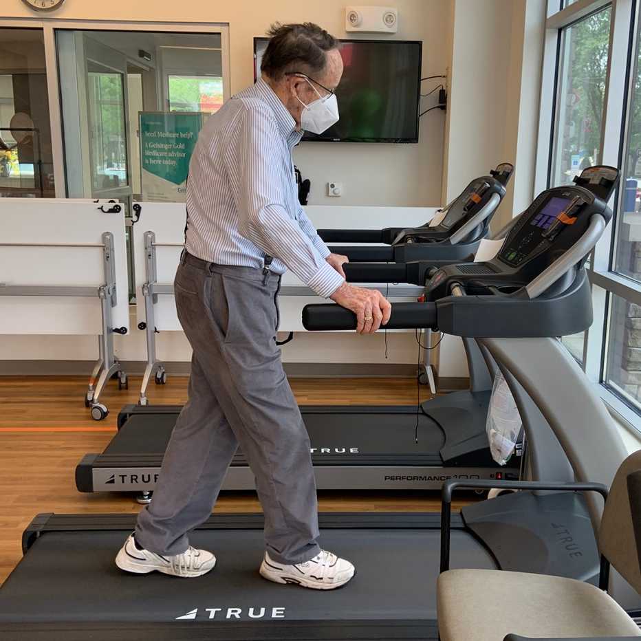 man using a treadmill, wearing a face mask