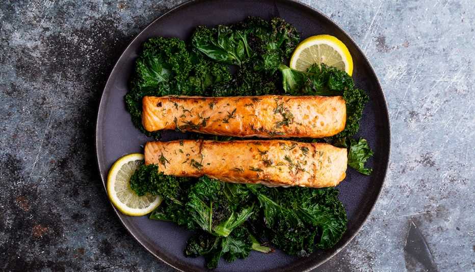 sautéed salmon fillets with kale, dill and lemon on a plate