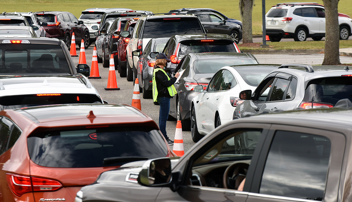 Cars line up as people wait to receive a dose of the COVID-19 vaccine at a drive-thru vaccination event at the Lake County Health Department in Clermont, Florida