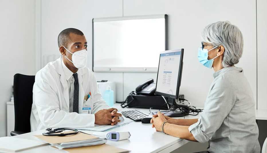 masked medical provider and patient in office setting