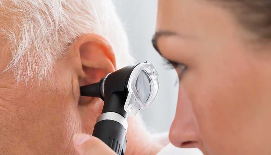 A doctor is looking into a person's ear