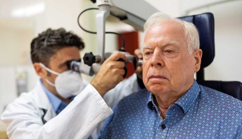 doctor examining the ear of a male patient