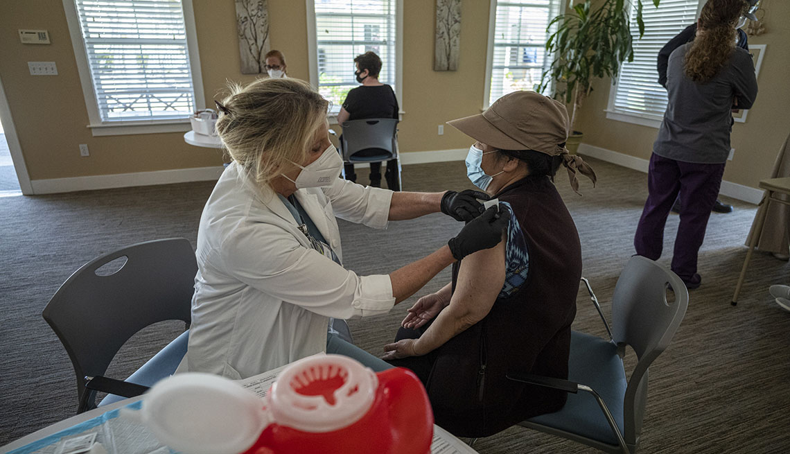 A healthcare worker wearing a protective mask and gloves administers a dose of the Johnson & Johnson Janssen Covid-19 vaccine.