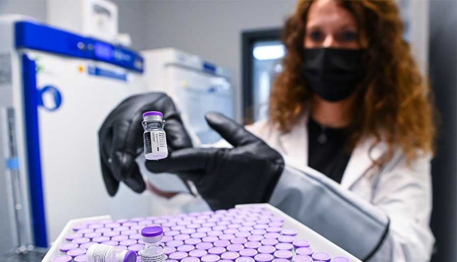 a healthcare technician unfrosts vials of a covid vaccine in a lab