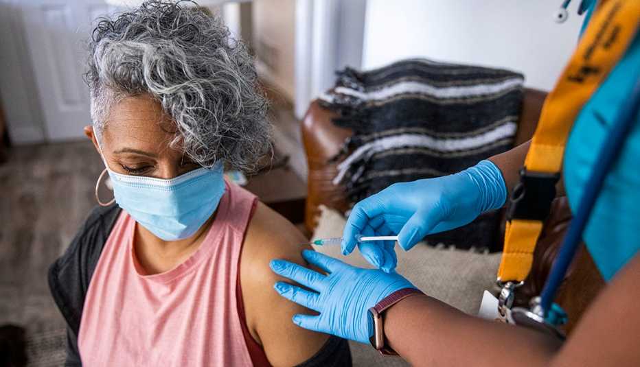 a nurse giving a COVID-19 vaccine to a senior black woman
