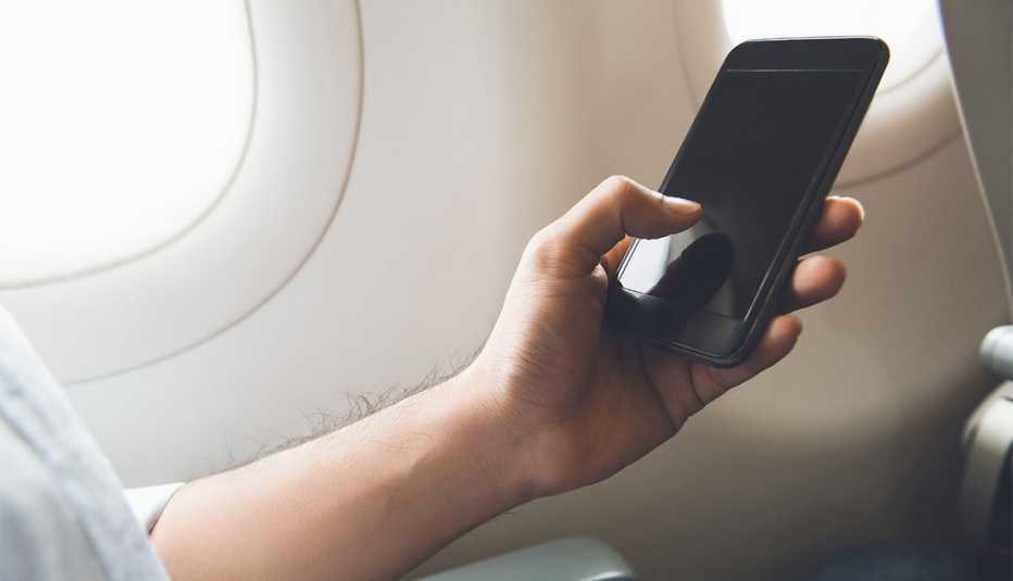 male passenger turning off mobile phone on the airplane for flight safety before flying