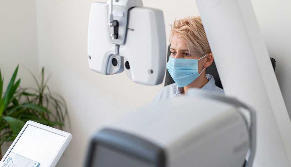 woman wearing a face mask and getting an eye exam