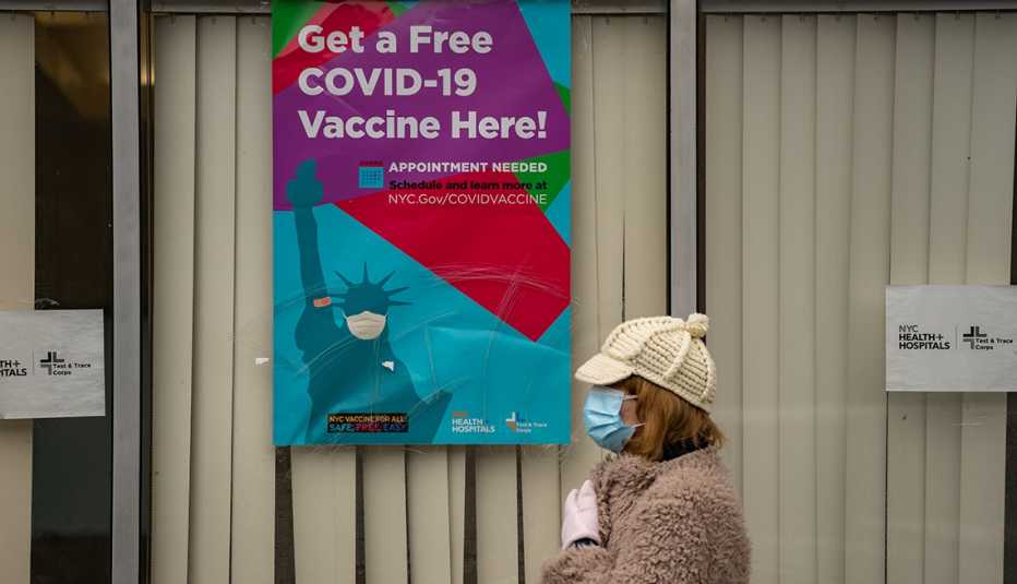 A woman wearing a face mask stands outside a COVID-19 vaccination site in New York City.