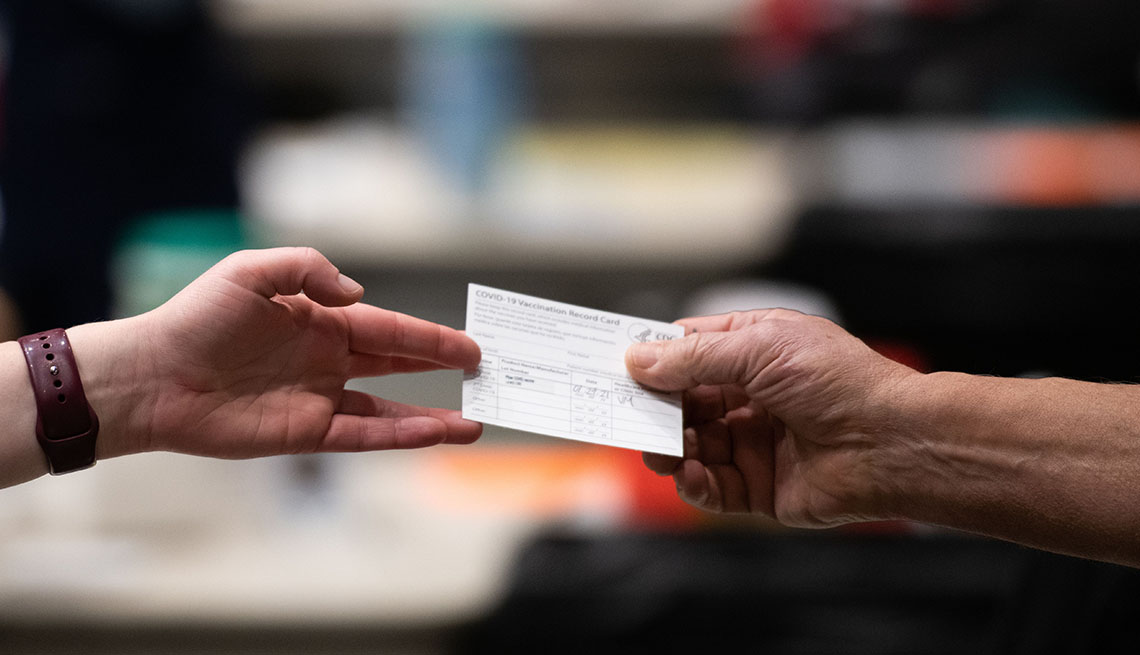 A patient receives a card showing when they received their first dose of the Pfizer Covid-19 vaccine.