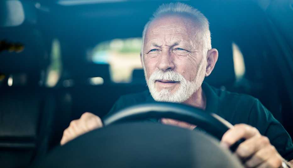 A man squinting while driving at night experiencing visual contrast sensitivity