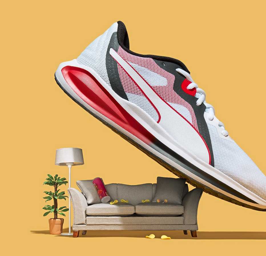 a giant sneaker looming over a sofa lamp and house plant