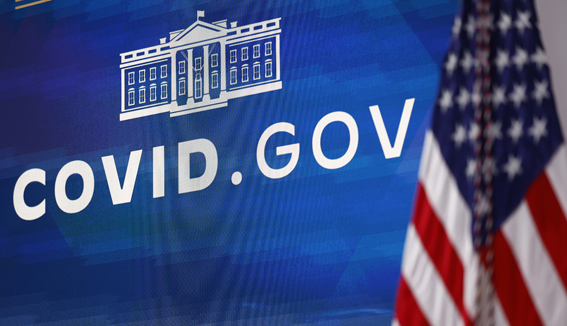 a video screen showing the white house logo and covid dot gov title from the press conference announcement of launch