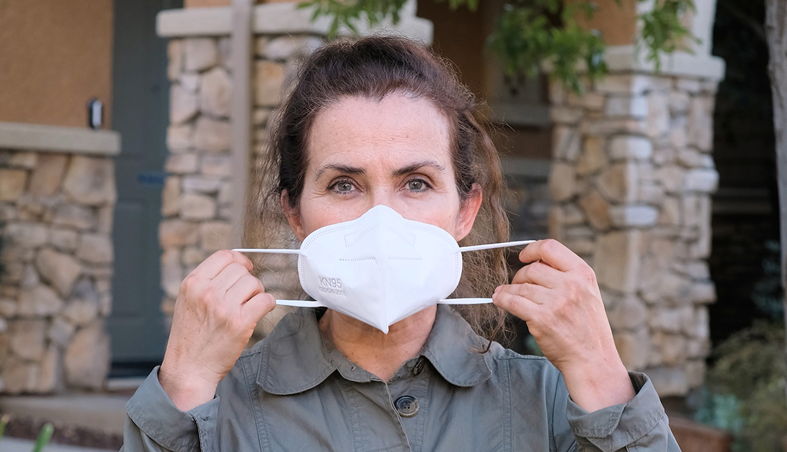 older woman about to put a N95 mask on