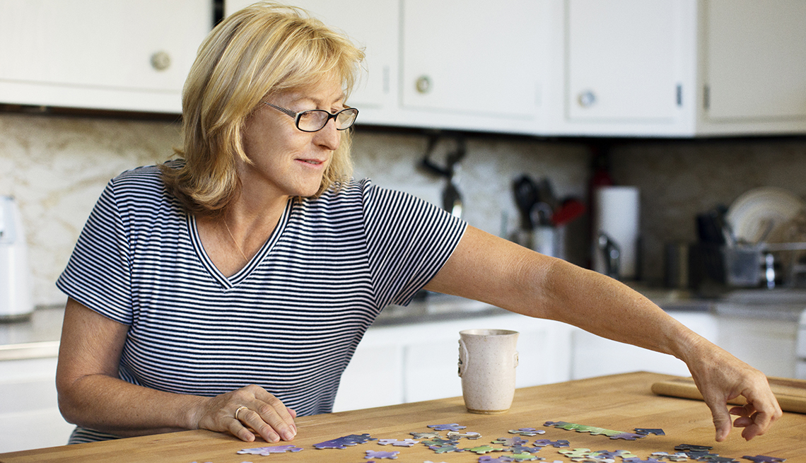 woman doing a puzzle in her kitchen