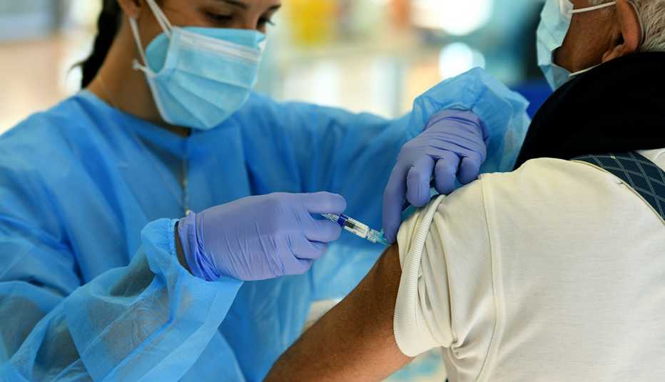 nurse prepares to administer a flu vaccination to a man