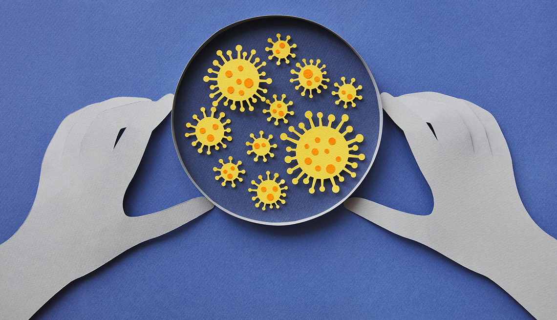 Conceptual illustration of a hand examining coronavirus in a petri dish on a blue background