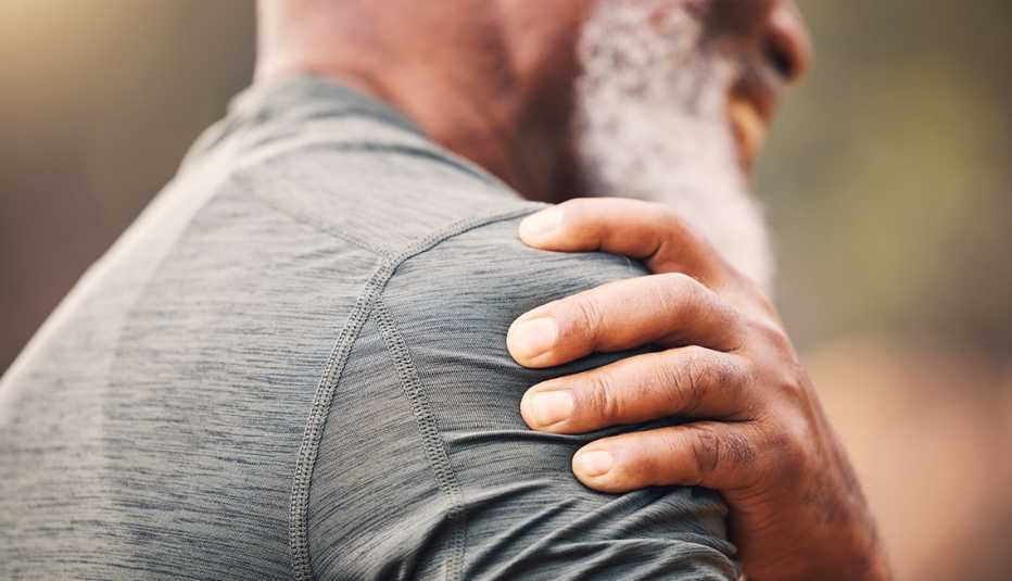 close up of a man in a gray shirt with a sore arm from flu shot