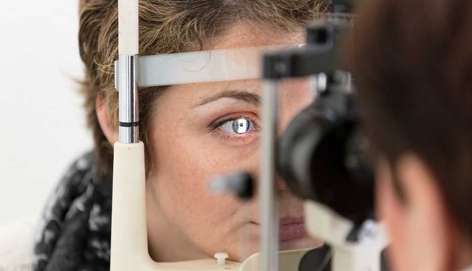 eye doctor checking woman's eyes