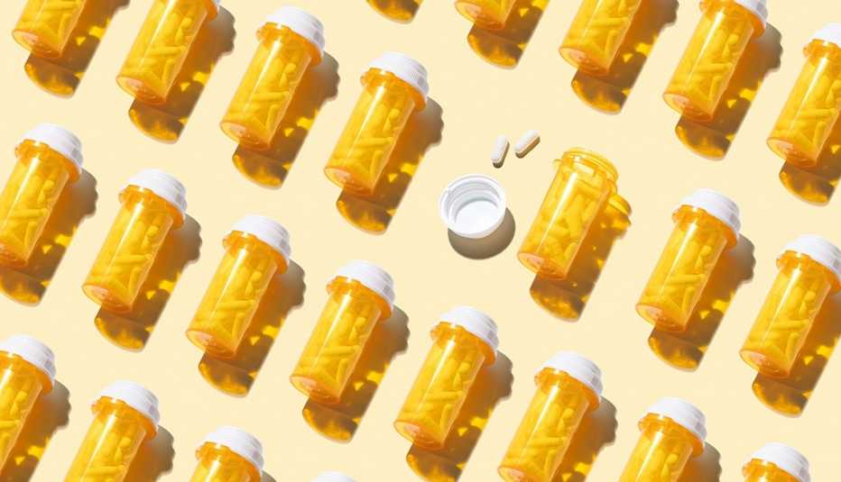 many orange pill bottles with white capsules on a light yellow background
