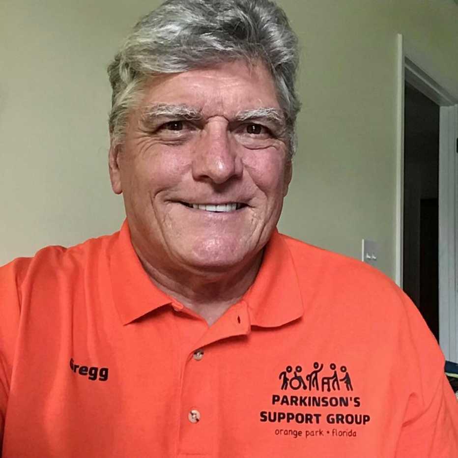 greg hummer wearing a polo shirt with the logo of the parkinsons support group on the left chest