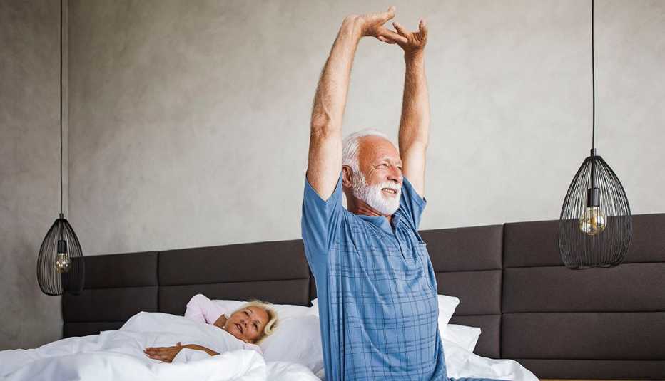 man stretching in bed as he wakes up
