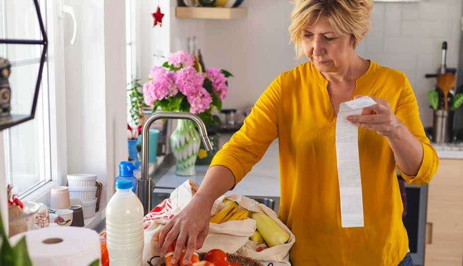 Woman going through her receipts at home after buying groceries 