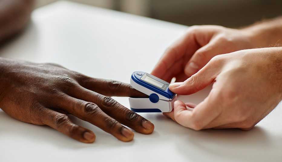 close-up shot of doctor applying pulse oximeter on patients finger during appointment