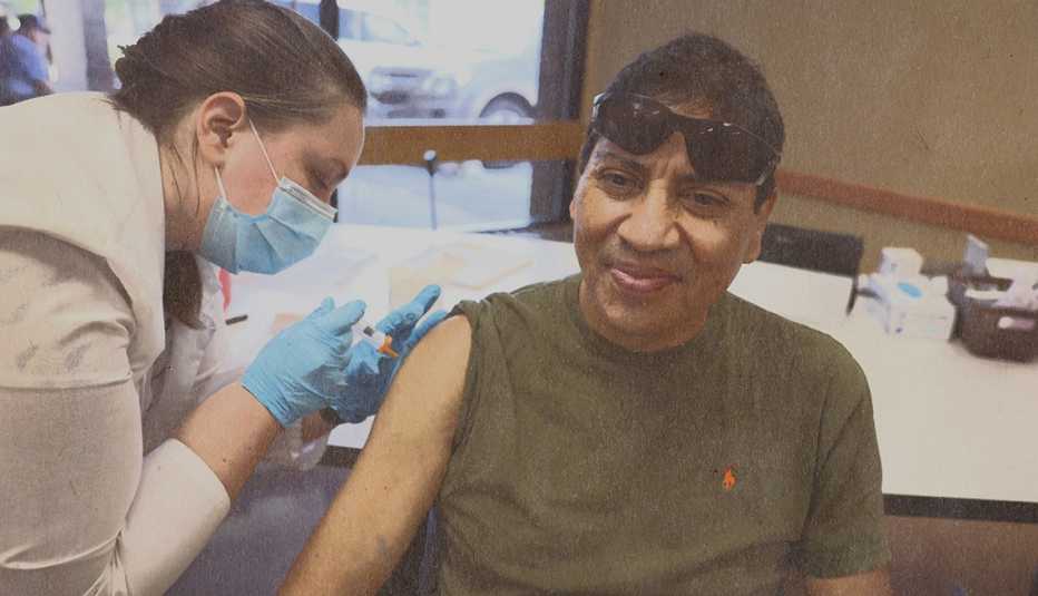 man with rolled up sleeve receiving a vaccine injection
