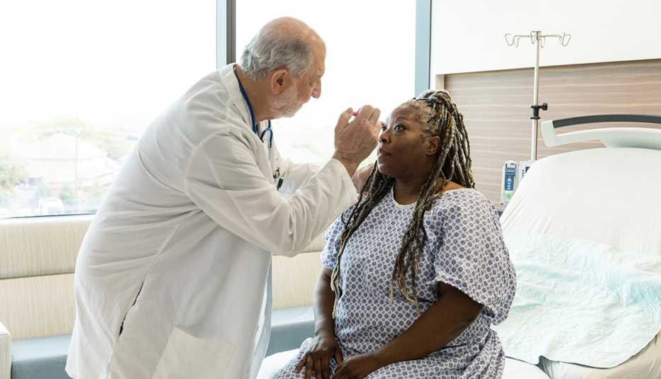 A male doctor examining a female patient's eyes for a concussion