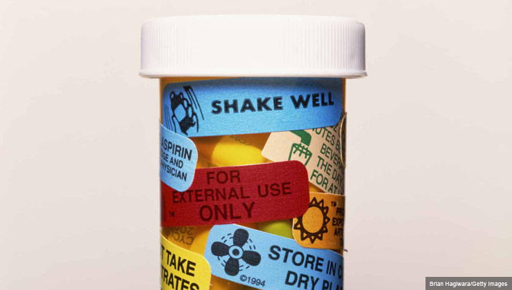 A prescription bottle with warning labels on it