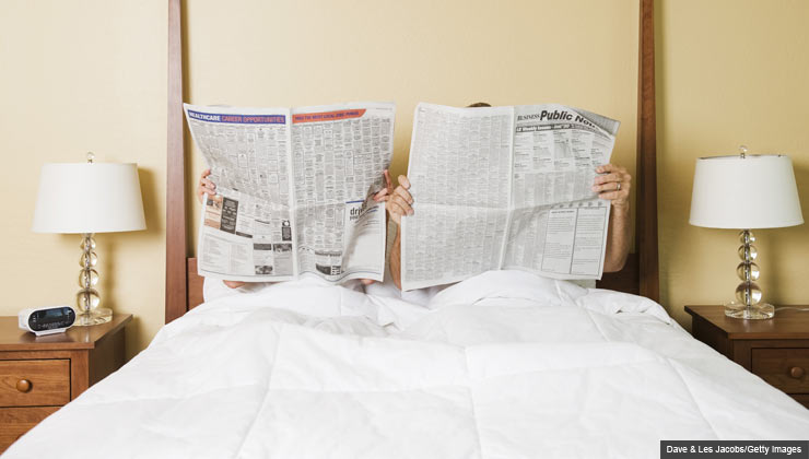 couple in bed reading newspaper - 7 Meds That Can Wreck Your Sex Life