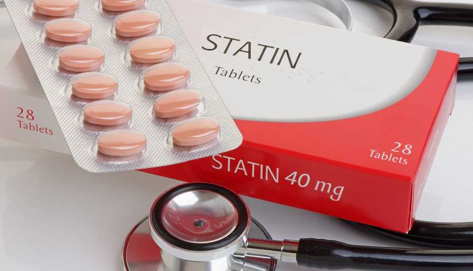 Statin pills on top of their box and a stethoscope nearby.