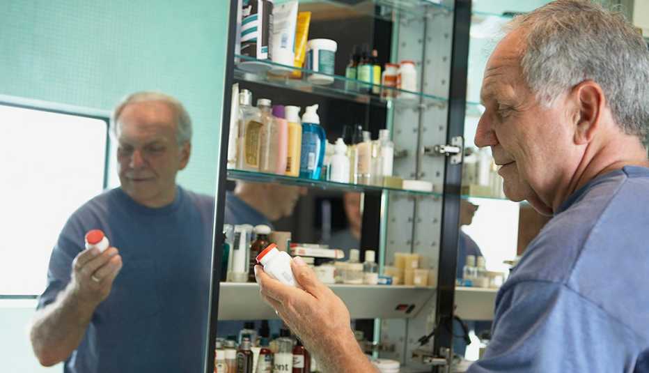 A man is looking through his medicine cabinet