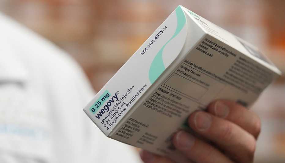close up of a pharmacist holding a box of Wegovy weight loss medication