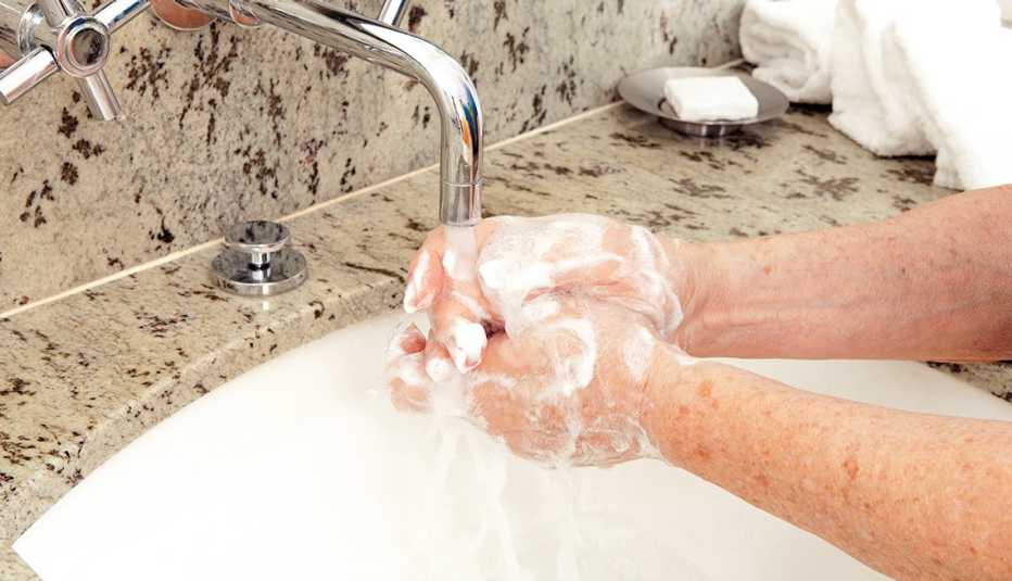 Woman washing her soapy hands in a bathroom 