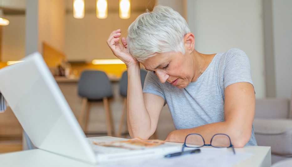 Frustrated older woman at computer looking at a bill
