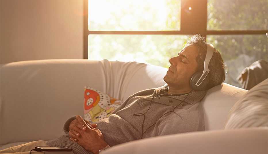 A man relaxing at home listening to music or a podcast