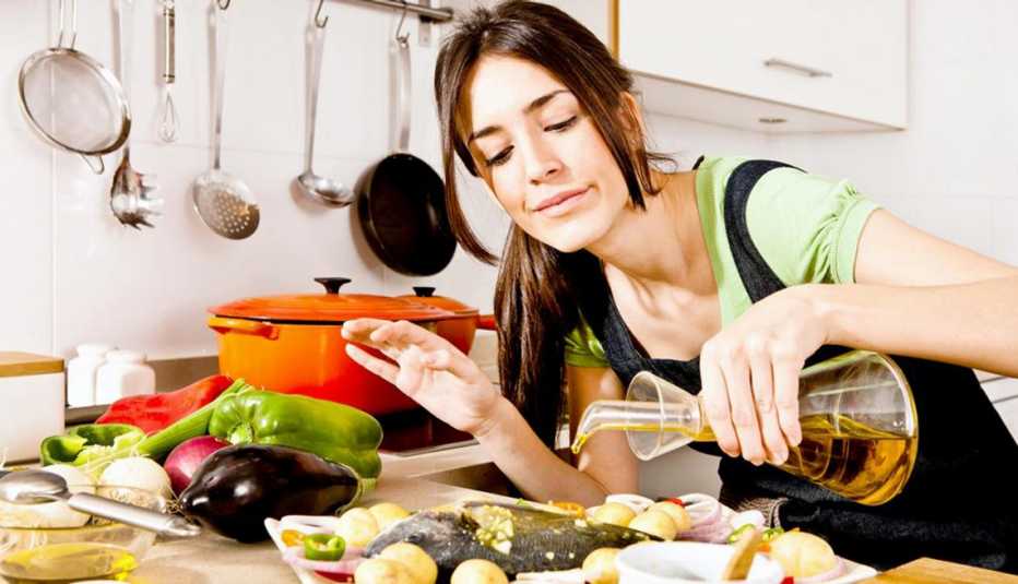 A Woman Pouring Oil over fish while Cooking, Good Fats, Healthy Living