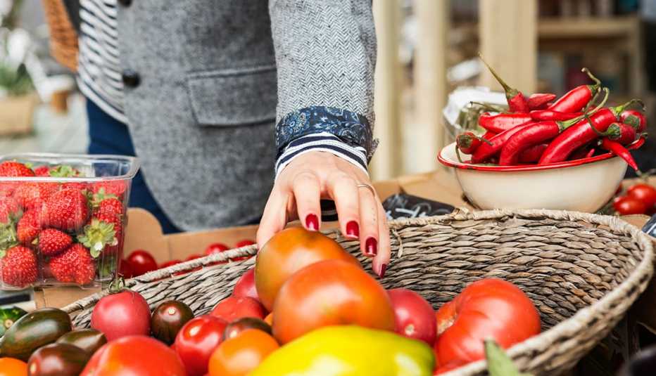 A woman reaches for tomatoes at a market, Live Cleaner, Healthy Living