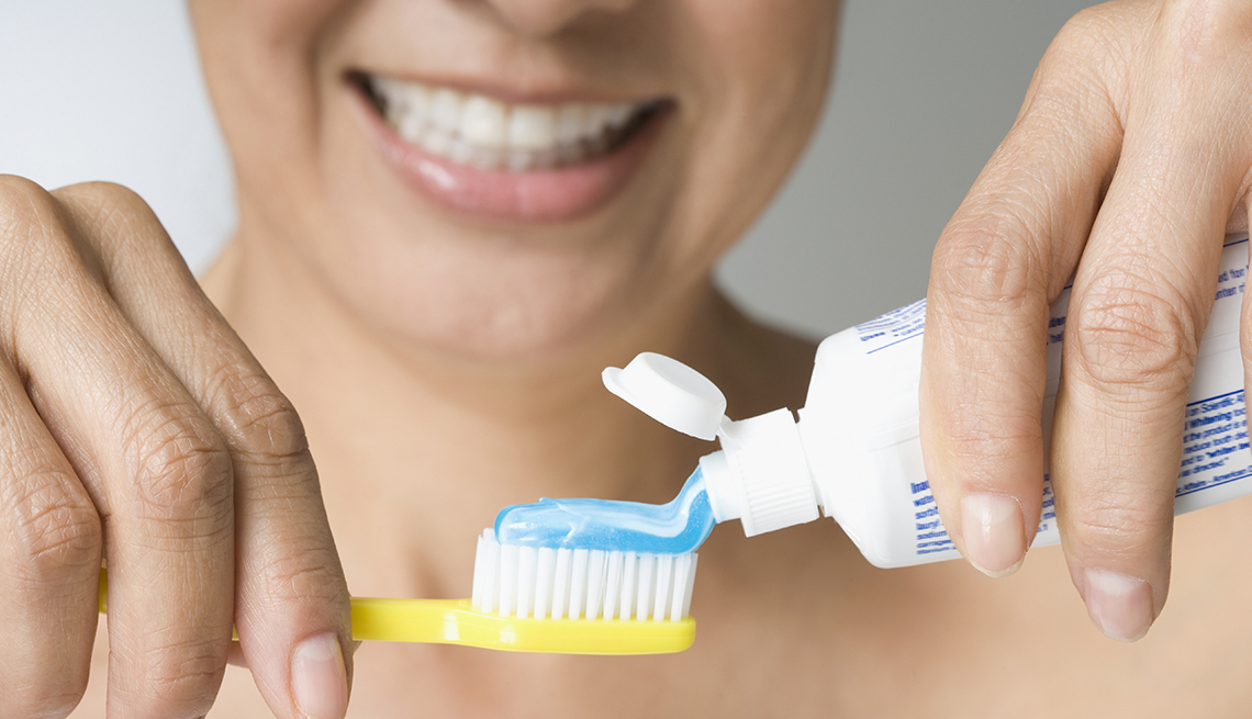 Woman holding tooth brush and toothpaste