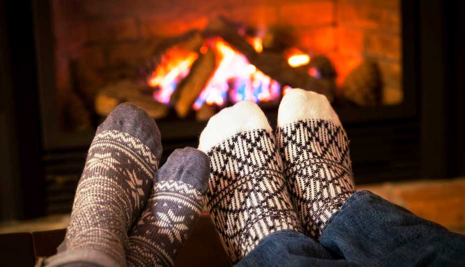 Feet in wool socks warming by cozy fireplace