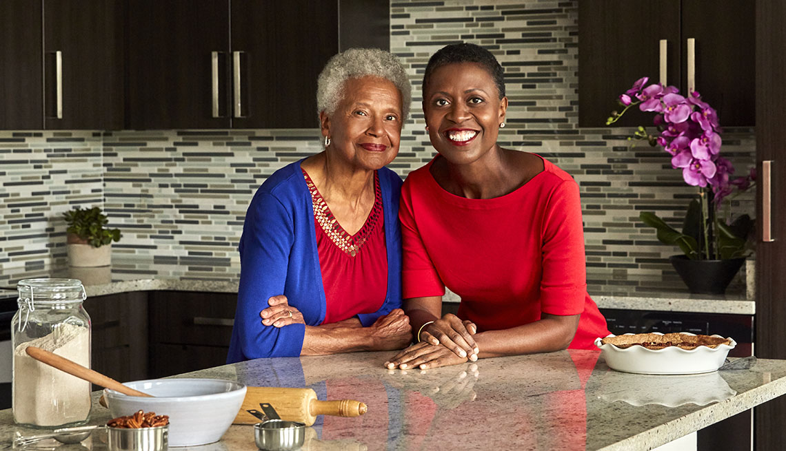 Daughter-mother cooks Tracye and Mary McQuirter leaning against a counter. A pecan pie sits next to them.