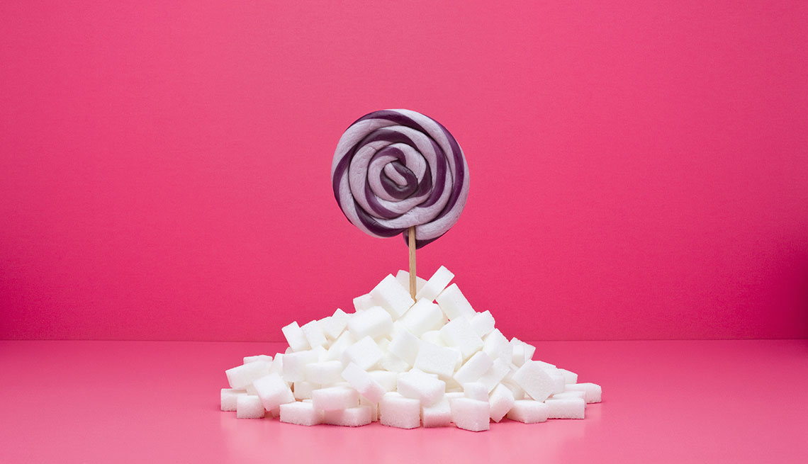 Food concept, lollipop sticking out from pile of sugar cubes