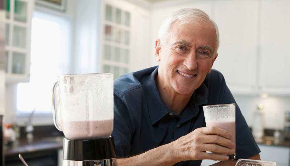 man drinking smoothie that he has just made in a blender