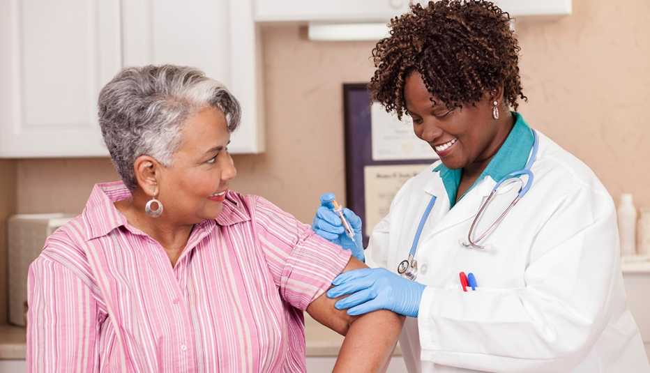 A woman gets a flu shot from a doctor
