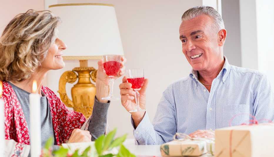 a male and female couple holding glasses with a red beverage