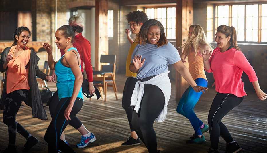 Group of young and middle aged women exercising and dancing in a gym. 